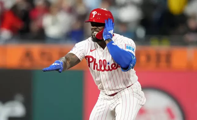 Philadelphia Phillies' Adolis García reacts after hitting a two-run double against San Francisco Giants pitcher Tyler Mahle during the sixth inning of a baseball game Tuesday, April 28, 2026, in Philadelphia. (AP Photo/Matt Slocum)