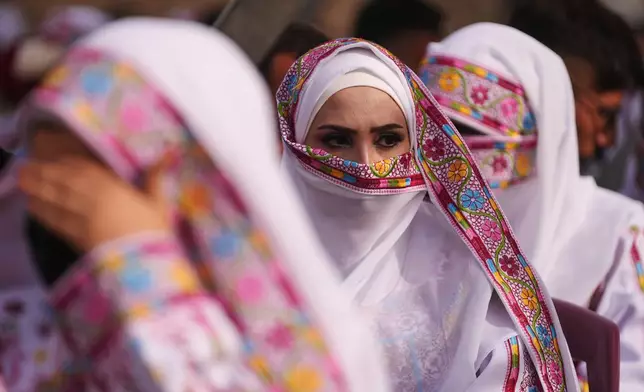 A Palestinian bride looks on as she gets married in a mass wedding ceremony in Deir al-Balah, central Gaza Strip, Friday, April 24, 2026. (AP Photo/Abdel Kareem Hana)
