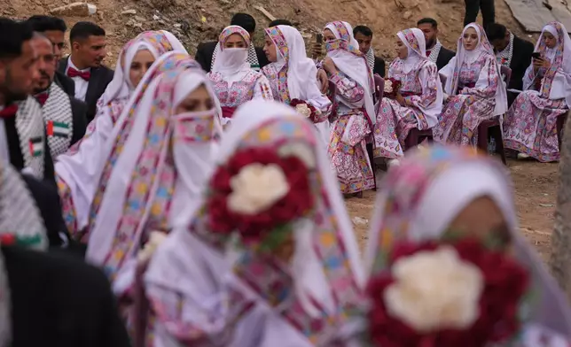 Palestinian couples participate in a mass wedding ceremony in Deir al-Balah, central Gaza Strip, Friday, April 24, 2026. (AP Photo/Abdel Kareem Hana)