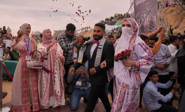 A Palestinian couple participates in a mass wedding ceremony in Deir al-Balah, central Gaza Strip, Friday, April 24, 2026. (AP Photo/Abdel Kareem Hana)