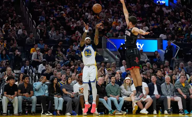 Golden State Warriors guard Gary Payton II (0) shoots a 3-point basket over Houston Rockets guard Reed Sheppard (15) during the first half of an NBA basketball game, Sunday, April 5, 2026, in San Francisco. (AP Photo/Godofredo A. Vásquez)