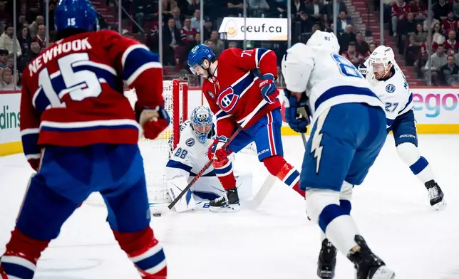 Tampa Bay Lightning goaltender Andrei Vasilevskiy (88) makes a save against Montreal Canadiens' Kirby Dach (77) during first-period NHL hockey game action in Montreal, Thursday, April 9, 2026. (Christopher Katsarov/The Canadian Press via AP)
