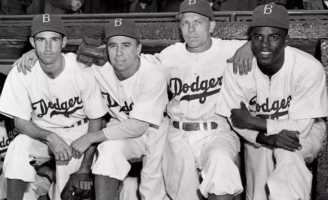 FILE - From left, Brooklyn Dodgers third baseman John Jorgensen, shortstop Pee Wee Reese, second baseman Ed Stanky, and first baseman Jackie Robinson pose before a baseball game against the Boston Braves at Ebbets Field in Brooklyn, N.Y., in this April 15, 1947, file photo. (AP Photo/Harry Harris, File)