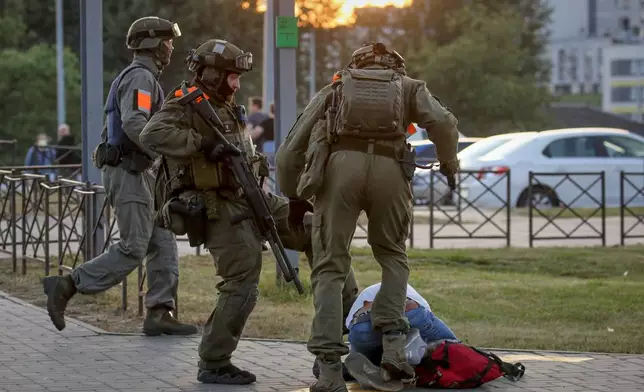 FILE - Police officers kick a demonstrator during a mass protest following presidential election in Minsk, Belarus, Monday, Aug. 10, 2020. (AP Photo, File)