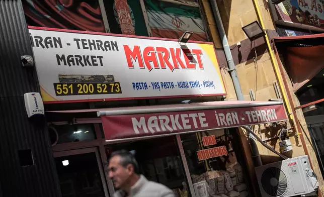 A man walks past an Iranian grocery shop in Istanbul on Tuesday, April 14, 2026. (AP Photo/Khalil Hamra)