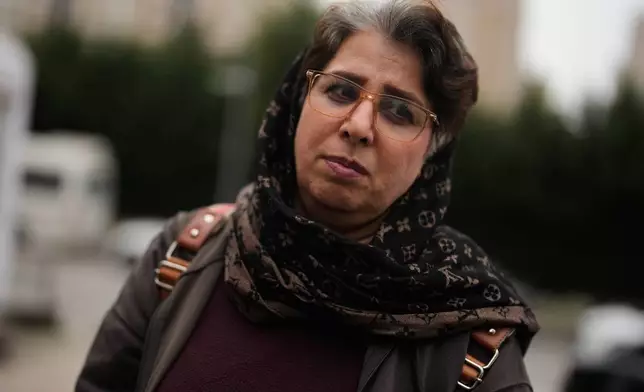 Sadri Haghshenas, a 47-year-old Iranian woman who works at a borek shop, walks in Istanbul on Tuesday, April 14, 2026. (AP Photo/Khalil Hamra)