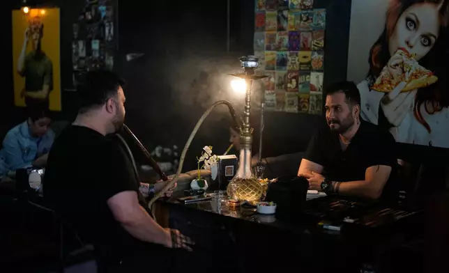 Nadr Rahim, right, sits with a friend at an Iranian coffee shop in Istanbul on Tuesday, April 14, 2026. (AP Photo/Khalil Hamra)