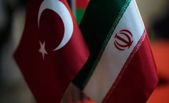 Turkish and Iranian flags are seen in an Iranian currency exchange business in the Aksaray district of Istanbul on Monday, April 13, 2026. (AP Photo/Khalil Hamra)