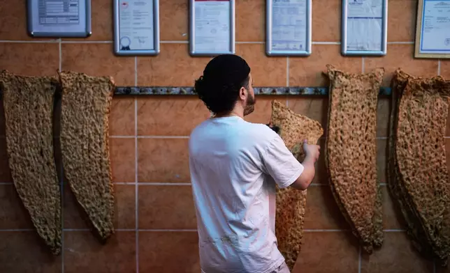 A baker hangs bread in an Iranian bakery in Istanbul on Tuesday, April 14, 2026. (AP Photo/Khalil Hamra)