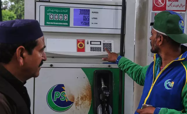 A motorcyclist looks at the display at a fuel station as he buys fuel after the government increased fuel prices amid surging global oil prices due to the Iran war, in Peshawar, Pakistan, Friday, April 3, 2026. (AP Photo/Muhammad Sajjad)