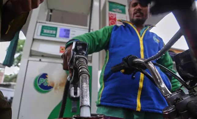 A worker fills fuel into a motorbike after the government increased fuel prices amid surging global oil prices due to the Iran war, in Peshawar, Pakistan, Friday, April 3, 2026. (AP Photo/Muhammad Sajjad)