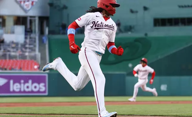 Washington Nationals' CJ Abrams, foreground, runs to score during the first inning of a baseball game against the Atlanta Braves, Monday, April 20, 2026, in Washington. (AP Photo/Daniel Kucin Jr.)