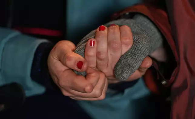 Project coordinator Christine Gruschka holds the hand of Monika Jansen 85, during a guided tour for people with dementia organized by Malteser Deutschland, part of the international Catholic aid organization Malteser Order of Malta, at the Zoo in Berlin, Germany, Thursday, March 26, 2026. (AP Photo/Markus Schreiber)