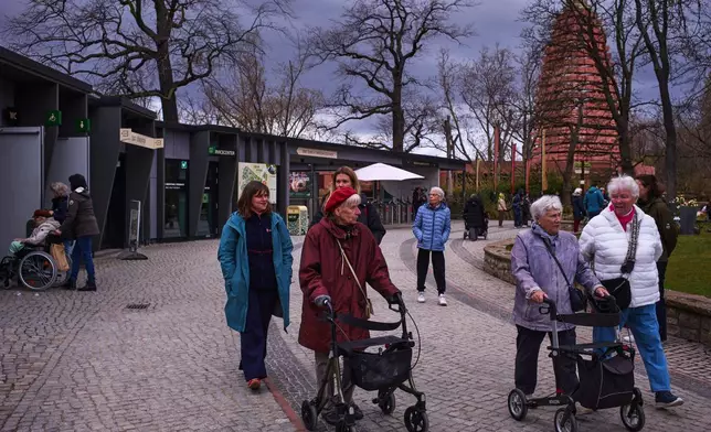 Monika Jansen, front left, and Christel Krueger, background center, take part in a guided tour for people with dementia organized by Malteser Deutschland, part of the international Catholic aid organization Malteser Order of Malta, at the Zoo in Berlin, Germany, Thursday, March 26, 2026. (AP Photo/Markus Schreiber)