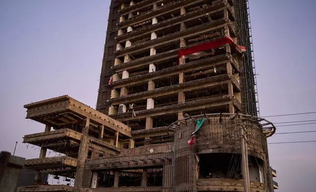 The remains of Sudanese flags flutter on a war-damaged building, in Khartoum, Sudan, Tuesday, April 21, 2026. (AP Photo/Bernat Armangue)