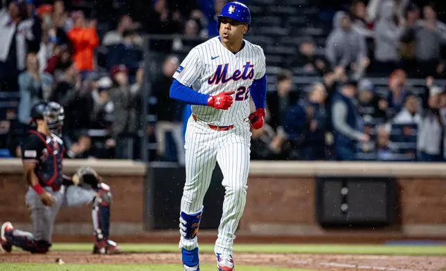 New York Mets' Juan Soto (22) spits out a seed as he scores a two-run home run during the fourth inning of a baseball game against the Washington Nationals, Tuesday, April 28, 2026, in New York. (AP Photo/Angelina Katsanis)
