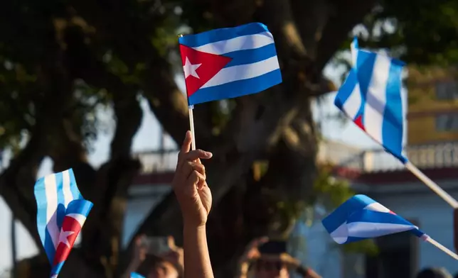 Women wave Cuban flags during a rally calling for the end of the U.S. blockade against the island nation in Havana, Cuba, Tuesday, April 7, 2026. (AP Photo/Ramon Espinosa)