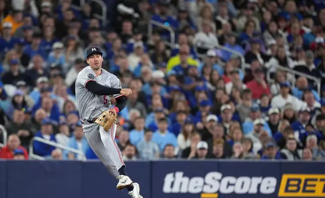 Minnesota Twins third baseman Ryan Kreidler makes a leaping throw to put out Toronto Blue Jays designated hitter George Springer at first base during third-inning baseball game action in Toronto, Saturday, April 11, 2026. (Nathan Denette/The Canadian Press via AP)