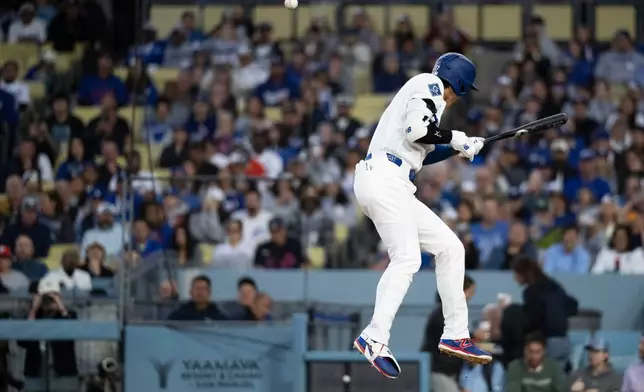 Los Angeles Dodgers' Shohei Ohtani takes a hit by pitch during the first inning of a baseball game against the New York Mets in Los Angeles, Monday, April 13, 2026. (AP Photo/Kyusung Gong)