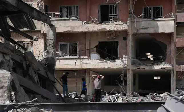 Residents inspect damage at the site of buildings destroyed in Israeli airstrikes, in Jibchit, southern Lebanon, Friday, April 17, 2026, following a ceasefire between Israel and Hezbollah. (AP Photo/Hassan Ammar)