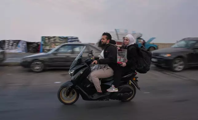 Displaced residents drive a motorcycle back to their villages following a ceasefire between Israel and Hezbollah, in Saida, Lebanon, Friday, April 17, 2026. (AP Photo/Hassan Ammar)