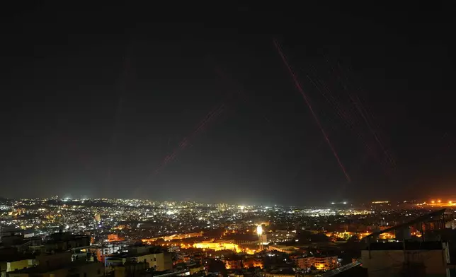 Tracer rounds illuminate the night sky as people fire live ammunition and fireworks into the air following a ceasefire between Israel and Hezbollah, in Beirut, Lebanon, early Friday, April 17, 2026. (AP Photo/Hassan Ammar)