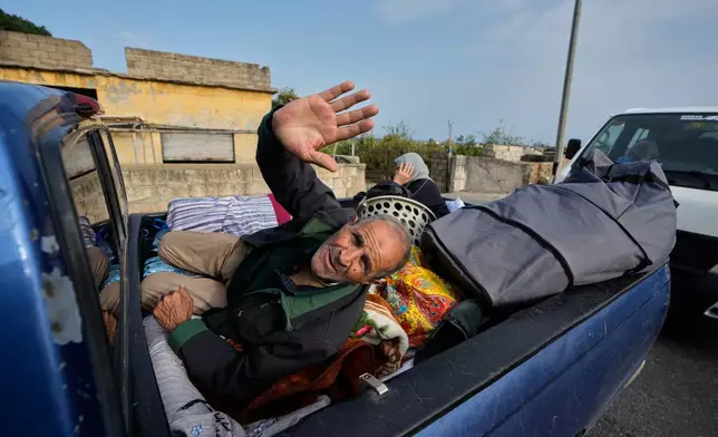 A displaced man gestures lying over belongings on a mini pickup, in Qasmiyeh near Tyre city, south Lebanon, as he returns with his family to their village following a ceasefire between Hezbollah and Israel, Friday, April 17, 2026. (AP Photo/Mohammed Zaatari)