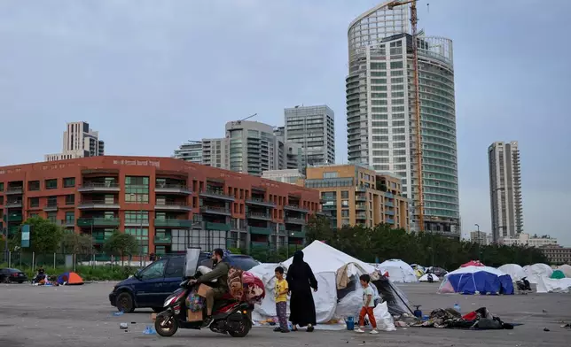 A displaced man with his family's belongings on a scooter prepares to return home following a ceasefire between Hezbollah and Israel in Beirut, Lebanon, Friday, April 17, 2026. (AP Photo/Hussein Malla)