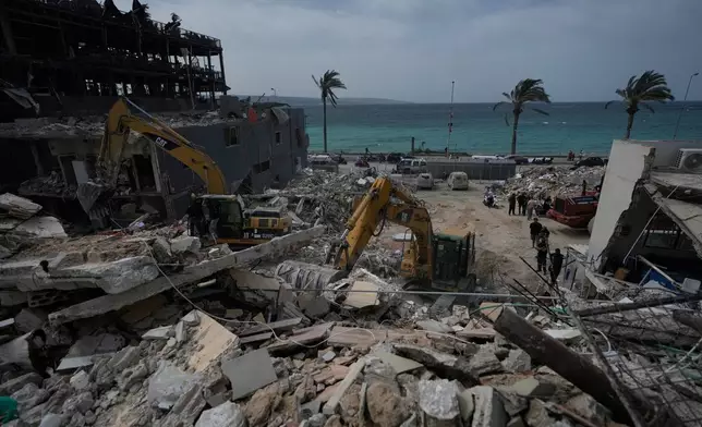 Rescuers search for victims in the rubble of a destroyed building that was struck in Israeli airstrikes in the city of Tyre, south Lebanon, Friday, April 17, 2026. (AP Photo/Mohammed Zaatari)