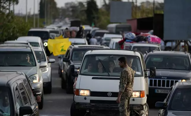 A Lebanese soldier stands as displaced people in cars queue up to cross a destroyed bridge in Qasmiyeh near Tyre city, south Lebanon, as they return to their villages following a ceasefire between Hezbollah and Israel, Friday, April 17, 2026. (AP Photo/Mohammed Zaatari)
