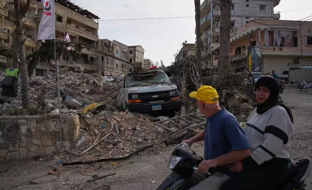Locals drive past the site of a building destroyed in an Israeli airstrike, in Jibchit, southern Lebanon, Friday, April 17, 2026. (AP Photo/Hassan Ammar)