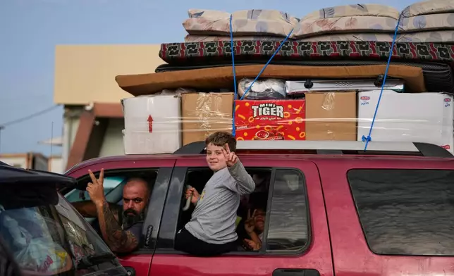 Displaced people flash victory signs in Qasmiyeh near Tyre city, south Lebanon, as they return to their village following a ceasefire between Hezbollah and Israel, Friday, April 17, 2026. (AP Photo/Mohammed Zaatari)