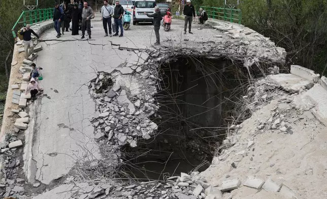 Displaced people walk across a destroyed bridge as they return to their villages, following a ceasefire between Hezbollah and Israel, in Tayr Felsay village, southern Lebanon, Sunday, April 19, 2026. (AP Photo/Bilal Hussein)