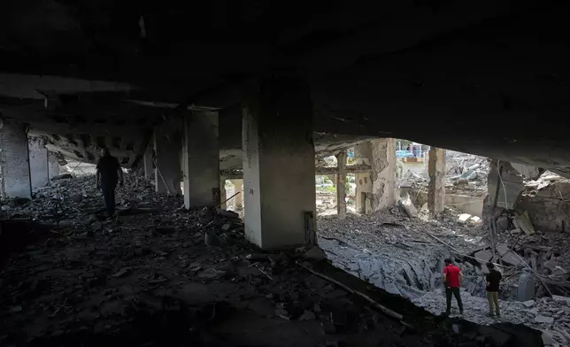 People walk among debris inside a mosque destroyed in an Israeli airstrike in Jibchit, southern Lebanon, Friday, April 17, 2026, following a ceasefire between Israel and Hezbollah. (AP Photo/Hassan Ammar)