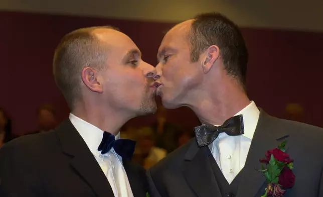 FILE -Gert Kasteel, left, and Dolf Pasker, who were among four couples to get married under the world's first law allowing same-sex marriages with equal rights, kiss after exchanging vows at Amsterdam's City Hall early April 1, 2001. (AP Photo/Peter Dejong, File)