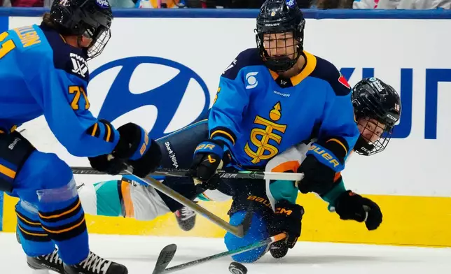 Toronto Sceptres' Kali Flanagan (centre) checks New York Sirens' Maddi Wheeler (18) as Sceptres' Anna Kjellbin (71) looks on during the third period of an PWHL hockey game in Toronto on Tuesday, April 21, 2026. (Frank Gunn/The Canadian Press via AP)