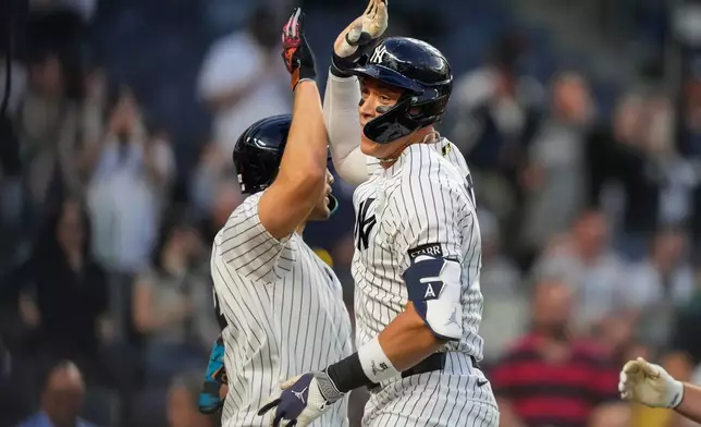 New York Yankees' Aaron Judge, right, celebrates with designated hitter Giancarlo Stanton, left, after hitting a two-run home run during the first inning of a baseball game against the Los Angeles Angels, Monday, April 13, 2026, in New York. (AP Photo/Yuki Iwamura)
