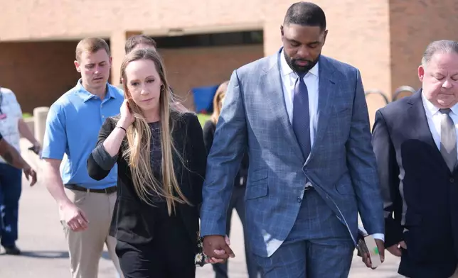 Former Michigan football coach Sherrone Moore and his wife Kelli leave court, Tuesday, April 14, 2026, in Ann Arbor, Mich. (AP Photo/Paul Sancya)