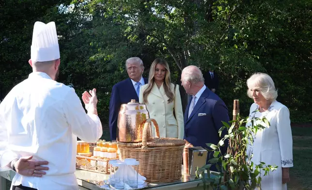 President Donald Trump and first lady Melania Trump andh Britain's King Charles III and Queen Camilla talk with White House assistant pastry chef Carlo Figarella as they look at a display at the White House garden on the South Lawn of the White House, Monday, April 27, 2026, in Washington. (AP Photo/Alex Brandon, Pool)