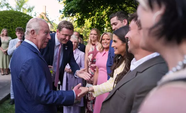 King Charles III shakes hands with CNN news anchor Kaitlan Collins during a garden party at the British Embassy, Monday, April 27, 2026, in Washington. (AP Photo/Julia Demaree Nikhinson, Pool)