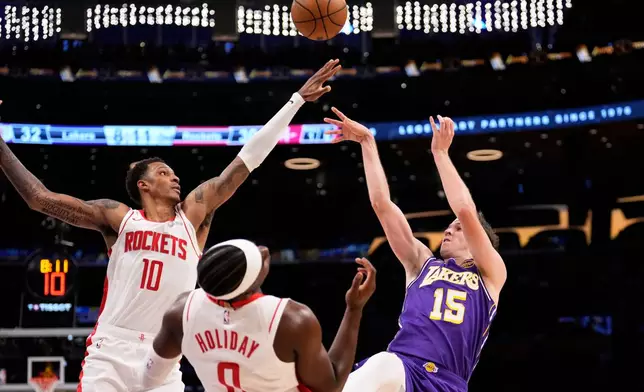 Los Angeles Lakers guard Austin Reaves, right, shoots as Houston Rockets forward Jabari Smith Jr., left, and guard Aaron Holiday defend during the first half in Game 5 of a first-round NBA playoffs basketball series Wednesday, April 29, 2026, in Los Angeles. (AP Photo/Mark J. Terrill)