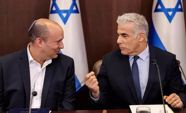 Israel's then caretaker Prime Minister Yair Lapid, right, talks with former Prime Minister Naftali Bennett during the weekly cabinet meeting in Jerusalem, on Sunday, Sept. 18, 2022. (Ronaldo Schemidt/Pool Photo via AP)