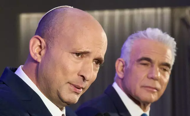 Former Israeli prime ministers Naftali Bennett, left, and Yair Lapid hold a joint press conference announcing that their parties will run together in the upcoming elections, in Herzliya, Israel, Sunday, April 26, 2026. (AP Photo/Ariel Schalit)