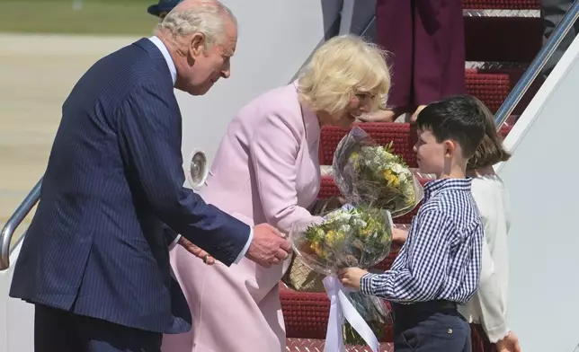King Charles III and Queen Camilla receive posies from the children of British military families based in the United States, at Joint Base Andrews, Md., Monday, April 27, 2026. They are in the U.S. for a four-day state visit aimed at celebrating the United States' 250th anniversary, including a White House state dinner and a speech to Congress. (AP Photo/Rod Lamkey, Jr.)