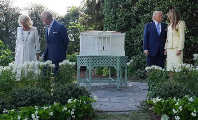 President Donald Trump and first lady Melania Trump along with Britain's King Charles III and Queen Camilla pose for a photo by White House bee hive at the White House, Monday, April 27, 2026, in Washington. (AP Photo/Alex Brandon, Pool)