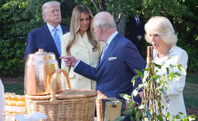 President Donald Trump and first lady Melania Trump andh Britain's King Charles III and Queen Camilla talk with White House assistant pastry chef Carlo Figarella as they look at a display at the White House garden on the South Lawn of the White House, Monday, April 27, 2026, in Washington. (AP Photo/Alex Brandon, Pool)