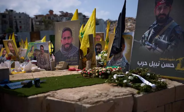 Graves bearing photos of Hezbollah fighters killed in Israeli strikes are seen in a cemetery in Choueifat, Lebanon, Monday, April 13, 2026. (AP Photo/Emilio Morenatti)