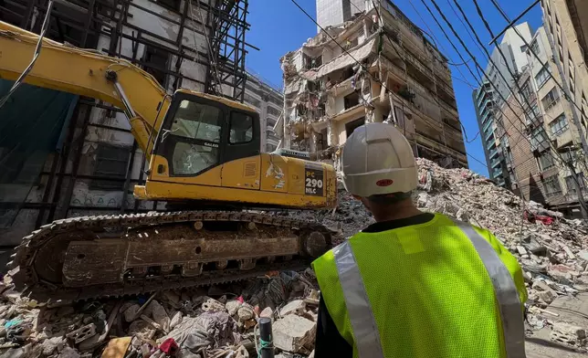 Workers remove the rubble, as rescuers keep searching for the bodies of a missing woman and girl at a destroyed building that was hit on Wednesday April 8, in an Israeli airstrike in Beirut, Lebanon, Monday, April 13, 2026. (AP Photo/Hussein Malla)