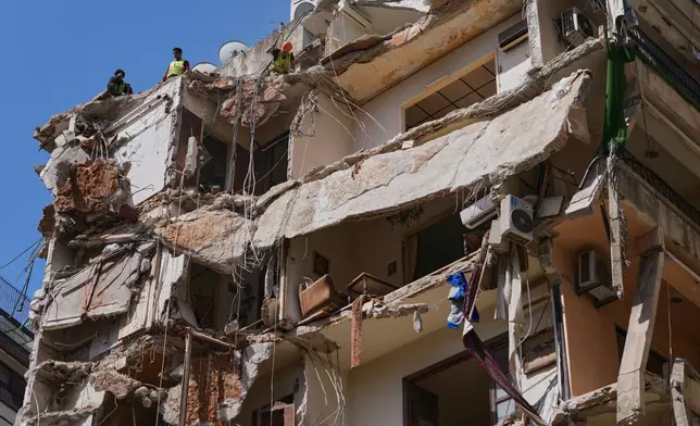 Workers remove the rubble as rescuers keep searching for a missing woman and girl at a destroyed building that was hit on April 8, in an Israeli airstrike in Beirut, Lebanon, Monday, April 13, 2026. (AP Photo/Hussein Malla)