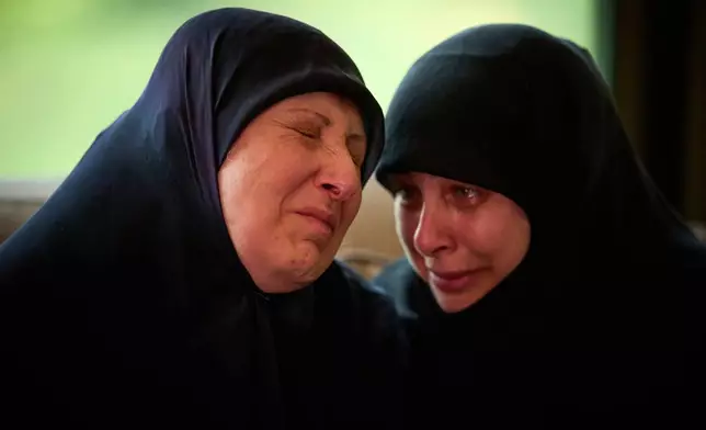 Ahlam Badawi, 51, left, mother of Hassan Ali Badawi, 31, a paramedic of the Lebanese Red Cross killed in a Israeli strike, cries during his funeral in Choueifat, Lebanon, Monday, April 13, 2026. (AP Photo/Emilio Morenatti)